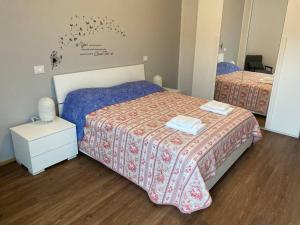 ein kleines Schlafzimmer mit 2 Betten und einem Spiegel in der Unterkunft Casa Eugenia in Varese