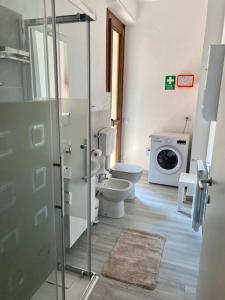 a bathroom with a toilet and a washing machine at Casa Eugenia in Varese