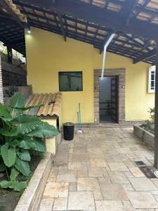 a patio of a house with a yellow wall at Hostel Parque Prainha in São Vicente