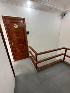 Cette chambre comprend 2 lits et une porte en bois. dans l'établissement Hostel Parque Prainha, à São Vicente