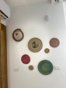 a wall with different types of plates on a wall at Appartement avec piscine et 10 min plage in Hammamet Nord