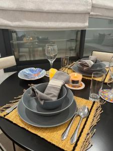 a dining room table with plates and utensils on it at Appartement avec piscine et 10 min plage in Hammamet Nord