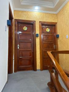 two wooden doors in a room with a staircase at Hostel Parque Prainha in São Vicente