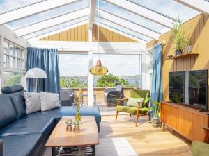 a living room with a blue couch and a large window at Holiday home Hejls LIII in Hejls