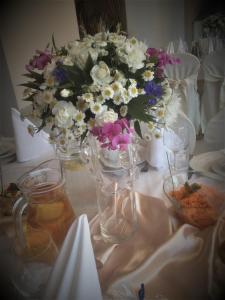 uma mesa com um vaso com flores em Hotel Janta em Dziemiany