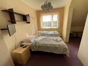 1 dormitorio con cama, mesa y ventana en Hotel Janta en Dziemiany