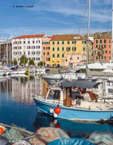 a blue boat is docked in a marina with buildings at Appuntamento Al porto in Savona