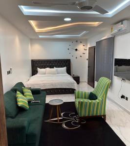 a bedroom with a bed and a couch and chairs at HMS SEA VIEW VILLA in Accra
