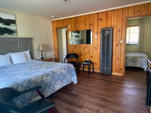 um quarto com uma cama e paredes de madeira em Bishop Village Motel em Bishop