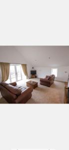 a living room with two couches and a table at Open plan house overlooking penshaw monument is in Sunderland