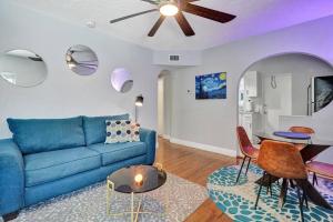a living room with a blue couch and a table at Retro Oasis by Las Olas in Fort Lauderdale