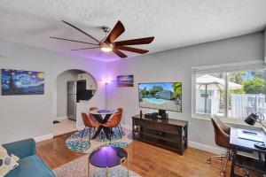 a living room with a ceiling fan and a table at Retro Oasis by Las Olas in Fort Lauderdale