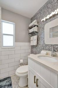 a white bathroom with a toilet and a sink at Retro Oasis by Las Olas in Fort Lauderdale