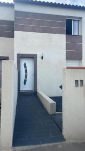 un bâtiment doté d'une porte blanche avec aigunigunigunigun dans l'établissement Suite Romantique Jacuzzi & Sauna privé Full options TV, à Perpignan