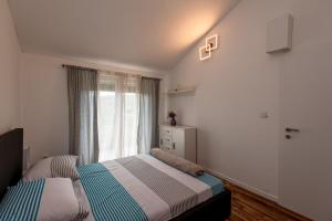 a bedroom with two beds in front of a window at Holiday House Mablo with pool & jacuzzi in Šibenik