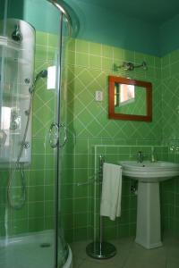 a green tiled bathroom with a shower and a sink at Edina Apartman in Zalakaros +25 photos
