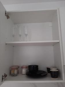 półka w kuchni z talerzami i okularami w obiekcie Apartamenty niedaleko plaży w Brodnicy