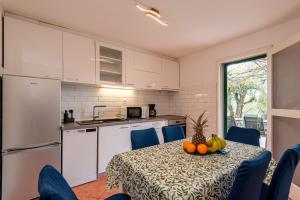 a kitchen with a table with a bowl of fruit on it at Holiday House Mablo with pool & jacuzzi in Šibenik