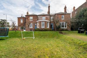 a large brick house with a net in the yard at Perfect for Large Family & Friends, Free Parking, Games in Reading