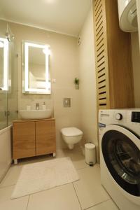 a bathroom with a sink and a washing machine at A blok - One bedroom apartment in Belgrade