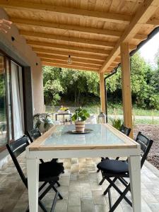 einen weißen Tisch und Stühle auf einer Terrasse in der Unterkunft La Marmotta COUNTRY RELAIS sul lago in Anguillara Sabazia