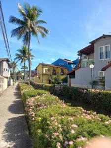 アングラ・ドス・レイスにあるSuíte Angraのヤシの木とピンクの花が咲く通り