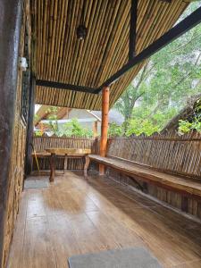 a wooden porch with a bench and a wooden fence at Big BamBoo Beach Resort Sipalay in Sipalay