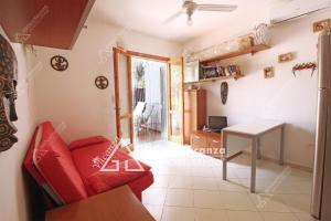 ein Wohnzimmer mit einem roten Sofa und einem Tisch in der Unterkunft GD Case Vacanza - Villetta Palegano - in Fontanelle