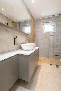 a bathroom with a sink and a glass shower at Aetherius Executive Suite 5 Min to BEACH in Kos Town