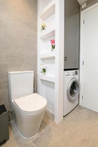 a bathroom with a toilet and a washing machine at Aetherius Executive Suite 5 Min to BEACH in Kos Town