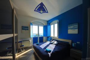 a blue bedroom with a bed with a blue wall at La Casa Sulla Spiaggia in Flumini di Quartu