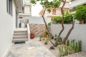 a courtyard with a tree and stairs in a house at Aetherius Executive Suite 5 Min to BEACH in Kos Town