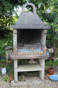 Hay un horno al aire libre en un jardín. en gite de l'aunay, en Fléré-la-Rivière