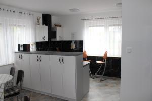 クリニツァ・モルスカにあるWilla Afrodytaの白いキャビネット、テーブルと椅子付きのキッチンが備わります。