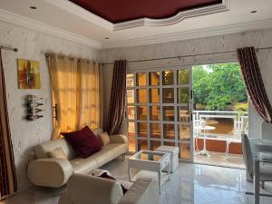 a living room with a couch and a large window at Appartement Altona in Lomé