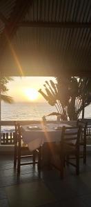 - une table avec vue sur l'océan au coucher du soleil dans l'établissement Résidence Callens, à Kribi
