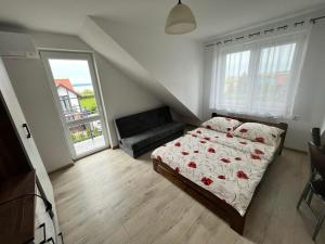 1 dormitorio pequeño con 1 cama y 1 sofá en Willa Afrodyta, en Krynica Morska