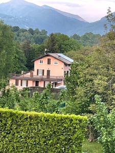 a house on a hill with mountains in the background at Cascina Del Galin in Lanzo dʼIntelvi
