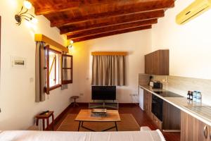 a living room with a table and a kitchen at Steni Traditional Studio Apartment in Paphos
