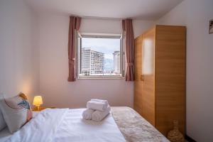 a bedroom with a bed with two towels on it at Villa Maxima Budva in Budva