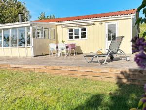 eine Terrasse mit einem Tisch und Stühlen sowie ein Haus in der Unterkunft 6 person holiday home in Knebel-By Traum in Knebel