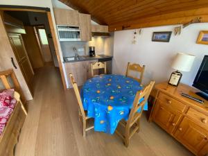 małą jadalnię z niebieskim stołem i krzesłami w obiekcie Appartement cosy proche centre et pistes, balcon, parking - FR-1-693-43 w mieście Châtel