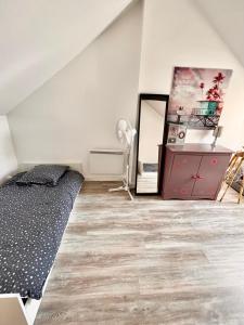 een slaapkamer met een bed, een dressoir en een spiegel bij Charmante maison au coeur de Villerville in Villerville