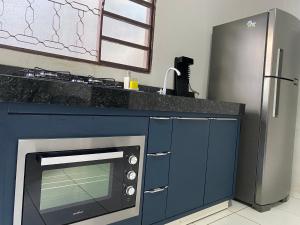 a kitchen with a microwave and a refrigerator at Flats LaMaison, Arse 81 in Palmas