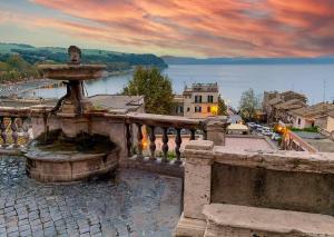 una fuente en un balcón con vistas al agua en La Marmotta COUNTRY RELAIS sul lago en Anguillara Sabazia