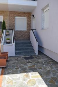 eine Lobby mit einer Treppe, einer weißen Wand und einem Fenster in der Unterkunft Nakis Apartment All Seasons in Stavros