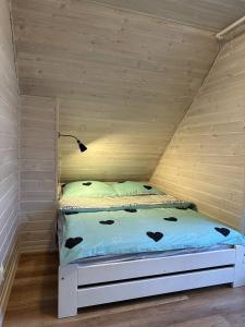 un lit dans une chambre avec un mur en bois dans l'établissement Domki i apartamenty Mila, à Sarbinowo