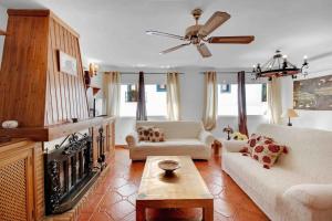 a living room with two couches and a ceiling fan at Duplex temático Andaluz con agradable terraza - El Mirador de Benahavis 2 in Benahavís