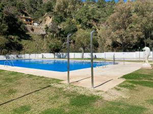 a swimming pool with a statue of a horse next to a fence at Duplex temático Andaluz con agradable terraza - El Mirador de Benahavis 2 in Benahavís