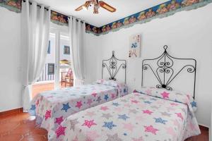 a bedroom with two beds and a ceiling fan at Duplex temático Andaluz con agradable terraza - El Mirador de Benahavis 2 in Benahavís +25 photos